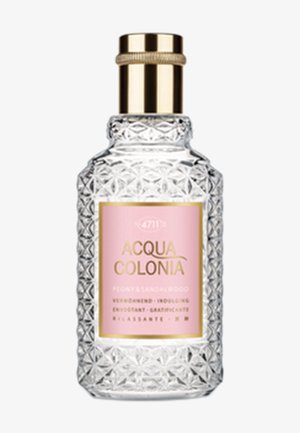Flacon de parfum en verre taillé avec un motif géométrique et une étiquette rose indiquant Acqua Colonia Menthe & Bois de Santal. Bouchon doré sur le dessus.