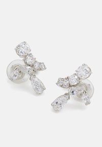 Lesklé strieborné náušnice s viacerými jasnými rhinestone v rôznych tvaroch, s oválnym a slzovitým designom, predvádzajúce zložitú detailnosť.
