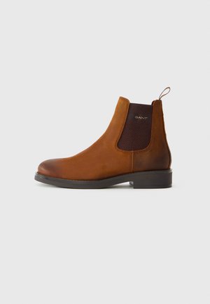 Brown leather Chelsea boot with elastic side panels, pull tab at the back, and low black heel on a plain white background.