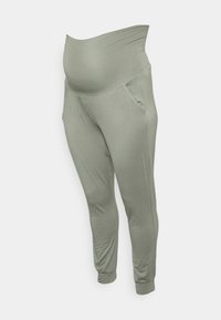 Calças de maternidade em verde claro com uma cintura suave e elástica, bolsos laterais, pernas ajustadas e um acabamento de tecido liso.