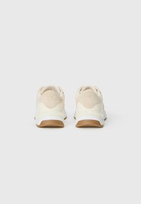 Hvite og beige joggesko med glatt lærfinish, suedepunkter, polstret krage og teksturert gummisåle. Logo på hælen.