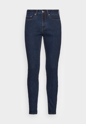 Dunkelblaue Slim-Fit-Jeans mit fünf Taschen, Knopfverschluss und sichtbaren Nähten auf einfarbigem Hintergrund.