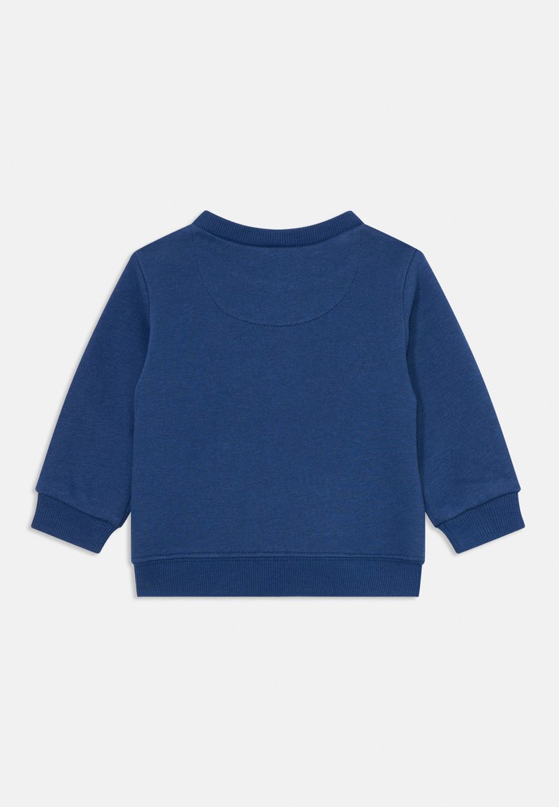 Sweat-shirt bleu à manches longues, avec des poignets et un col côtelés. Tissu doux avec une texture unie, présentant un détail de couture au niveau de l'empiècement au dos.