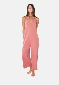 Mono rosa sin mangas con escote en V, corte relajado, piernas anchas y tejido suave, con tirantes finos y diseño minimalista.