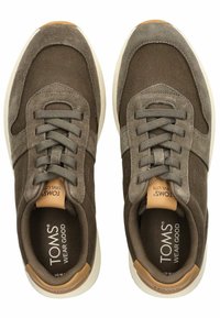 Hnědé textilní a semišové sneakers s bílou podrážkou, s šedými tkaničkami, hnědým akcentem na patě a nápisem "TOMS WEAR GOOD" uvnitř.
