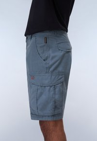 Pantalones cortos de carga de color azul claro, fabricados en tela, con múltiples bolsillos, un dobladillo cosido y un pequeño emblema de bandera en el lateral.
