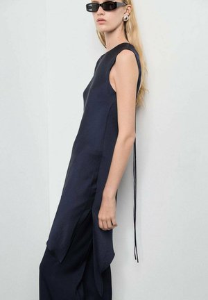 Vestido sin mangas de color azul marino con un diseño elegante, aberturas laterales y un largo lazo decorativo. Textura suave con acentos minimalistas.