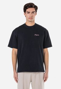 Tricou din bumbac negru cu mâneci scurte și guler rotund. Prezintă broderie roz "Peyador" pe piept. Croială simplă și lejeră.