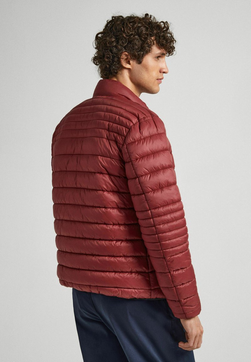 Burgundowa kurtka puchowa z poziomym pikowaniem, z kołnierzem stojącym i długimi rękawami, wykonana z błyszczącego, lekkiego materiału.