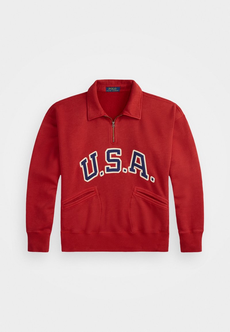 Sweatshirt rouge à col zippé, arborant un grand texte "U.S.A." en bleu marine. Deux poches avant et des poignets côtelés complètent le design.