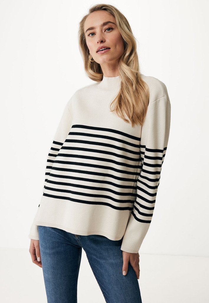 Pull crème avec des rayures horizontales noires, col rond, coupe décontractée et finitions côtelées à l'ourlet et aux poignets, associé à un jean bleu.