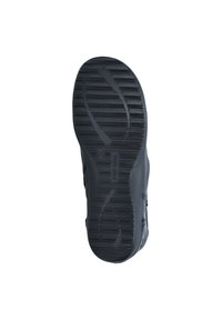 Semelle de chaussure en caoutchouc noir avec un design de crantage texturé. Présente des lignes courbes et des nervures pour une meilleure traction. Bord renforcé et détail de marque visible.