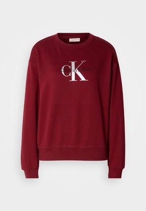 Sweatshirt bordeaux com decote redondo, mangas longas e um logotipo prateado "Calvin Klein". Tecido suave com um corte descontraído e punhos canelados.