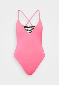 Maillot de bain une pièce rose avec un décolleté en V profond, des bretelles croisées noires arborant un logo blanc, et un tissu lisse et extensible.