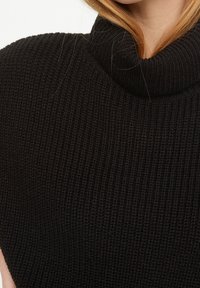 Mustat neulotut poolopaidat, joissa on tekstuurikuvio ja leveä kaulus, ja jotka ovat ribbettymuotoisia ja pehmeästä kankaasta.