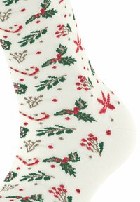 Kniestrümpfe in Weiß mit einem Weihnachtsmotiv, das rote und grüne Stechpalmenblätter, Beeren und florale Akzente in einer gestrickten Textur zeigt.