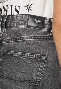 Černé džíny z denimu mají texturovanou tkaninu s vybledlým povrchem. Obsahují zadní kapsy a koženou nášivku s logem "Pepe Jeans".