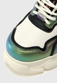 Witte sneaker met iriserende teal en zwarte accenten, voorzien van een gestructureerde afwerking, witte veters en een gevoerde tong met logo-detail.