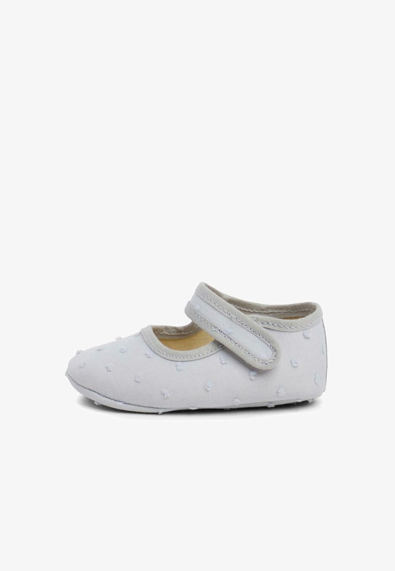 Chaussure en tissu gris clair avec un bout rond, une sangle Velcro, un motif à pois texturé et un intérieur doux et rembourré.