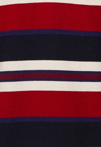 Tejido de punto con rayas horizontales en rojo, blanco, marino y púrpura oscuro. Textura suave con una distribución de color uniforme.