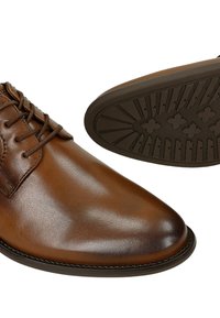 Scarpe stringate in pelle marrone con finitura liscia, dotate di punta rotonda, design con lacci e suola in gomma testurizzata con motivi geometrici.