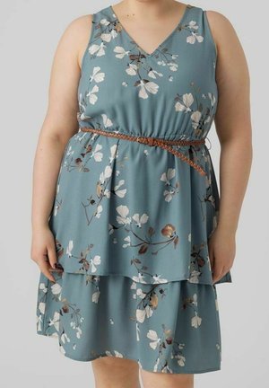 Floral dress in teal fabric with a V-neckline, layered design, and brown belt detail. Features large white and brown flowers.