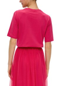 Fuchsia roze cropped t-shirt met korte mouwen, gemaakt van zachte stof, gecombineerd met een bijpassende tulle rok met een gerimpelde taille.