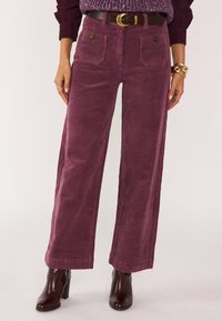 Paarse corduroy wijdvallende broek met voorzakken, een hoge taille en een gestructureerde afwerking, gecombineerd met bruine leren enkellaarsjes met hoge hak.