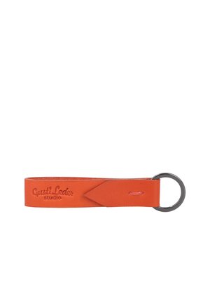 Orangene Leder-Schlüsselanhängerschlaufe mit eingeprägtem "Gusti Leder studio" und an einem silbernen Metallring auf weißem Hintergrund befestigt.