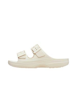 Sandalo beige con due cinturini regolabili con fibbia e suola testurizzata per aderenza e comfort.
