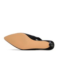 Zapato negro de punta afilada con un diseño elegante, que presenta un tacón bajo y una suela estrecha. Acabado suave en la parte superior con un estilo sin cierre.