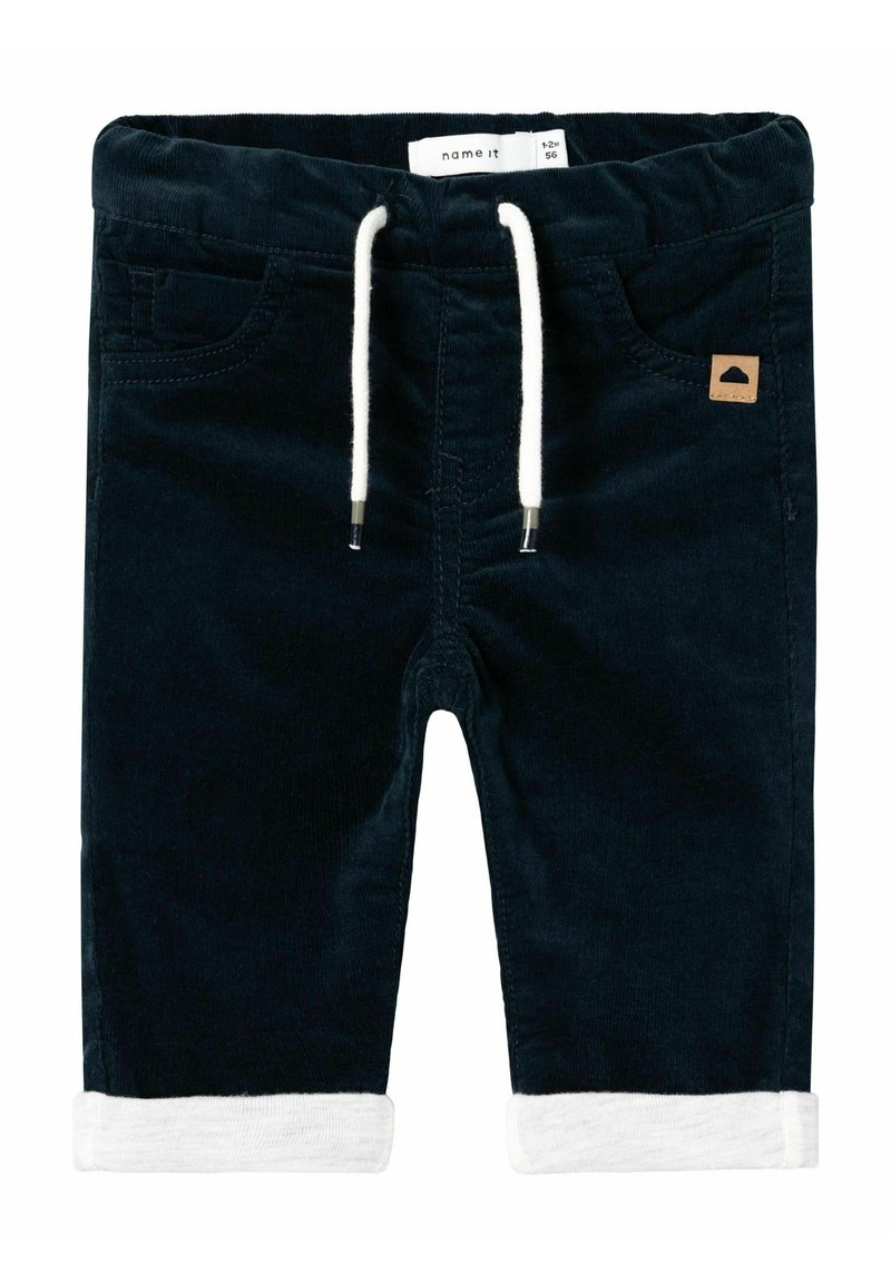 Pantaloni corti in corduroy di un blu scuro con una comoda vita elastica, coulisse bianca, risvolti bianchi e un piccolo dettaglio in pelle color beige.