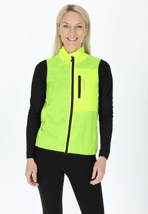 Helles Gelb, ärmellose Windjacke mit vollem Reißverschluss, ausgestattet mit einer Reißverschlusstasche auf der Brust und einem Stehkragen. Schwarze Ärmel darunter.