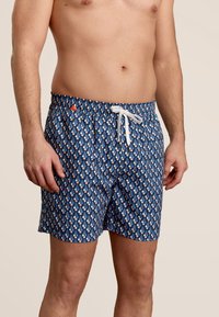 Heren zwembroek van blauwe stof met een driehoekig patroon in roze en wit, elastische tailleband met een trekkoord en zijzakken.