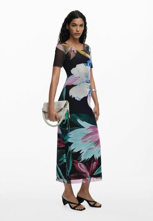 Vestido negro con un corsé ajustado y una falda fluida, con grandes patrones de flores coloridas, combinado con un bolso de mano gris y sandalias de tacón negras.