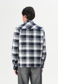 Kontrollert flanellskjorte i marineblå og hvit, med lange ermer, knapplukking og klassisk krage, med rett nederkant og detalj med bakf lease.