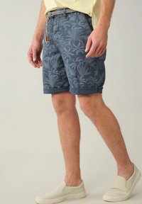 Shorts navy avec motif de feuilles de palmier, ourlet roulé et taille à cordon. Assortis avec des chaussures légères à enfiler.