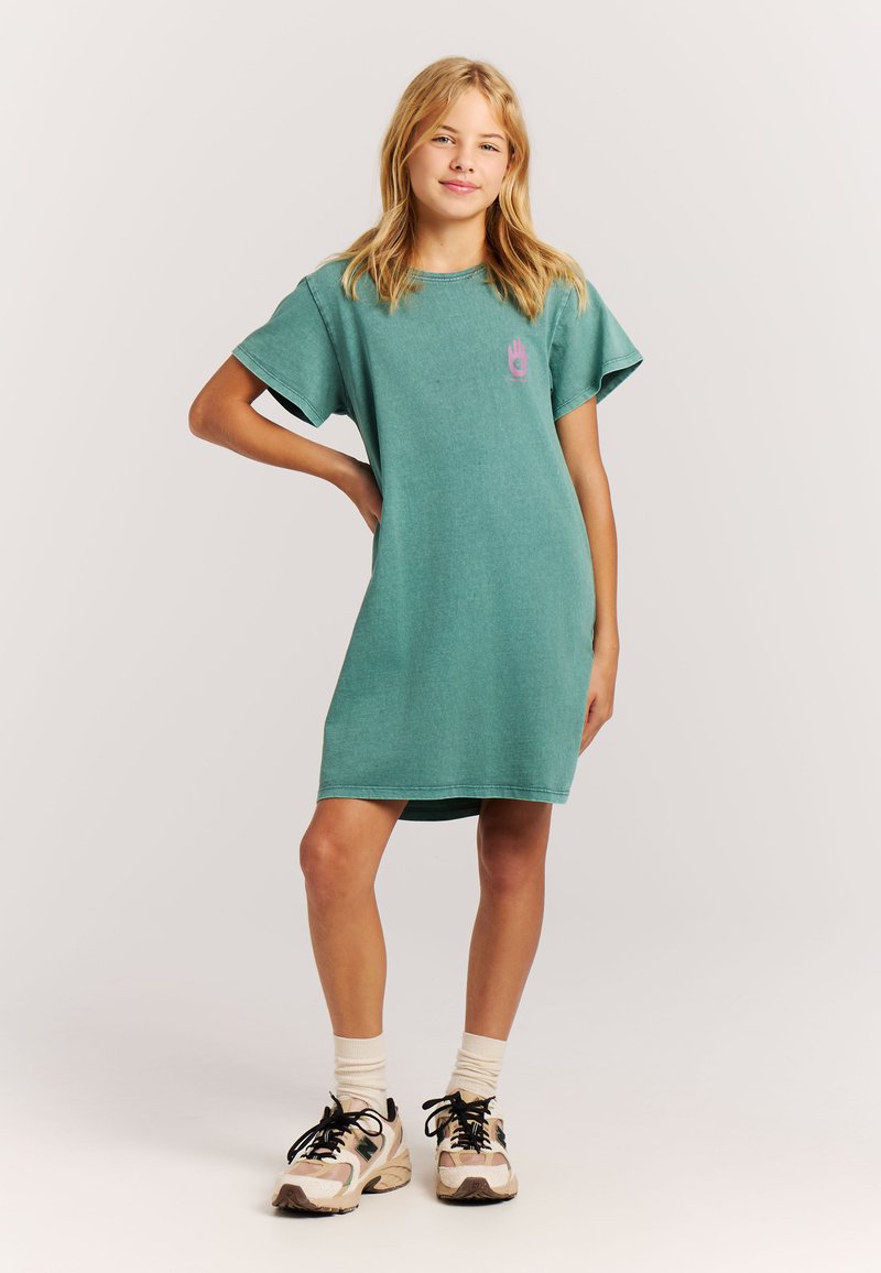 Mintgrøn bomulds t-shirt kjole med korte ærmer, rund halsudskæring og en pink håndgrafik på brystet. Båret med sorte og beige sneakers.