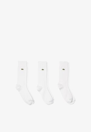 Drei Paar weiße Baumwollsocken mit einem kleinen, grünen, gestickten Krokodillogo, einer glatten Textur und einem klassischen Crew-Design.