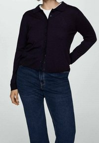 Tmavě fialový cardigan s límečkem, zapínáním na knoflíky a ribbovanými manžetami, v kombinaci s modrými džíny. Hladká textura.
