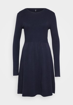 Tengerészkék kötött ruha hosszú ujjakkal, bordázott textúrával a mellrészen, harangszoknyával és kerek nyakkivágással. Puha és rugalmas anyag.