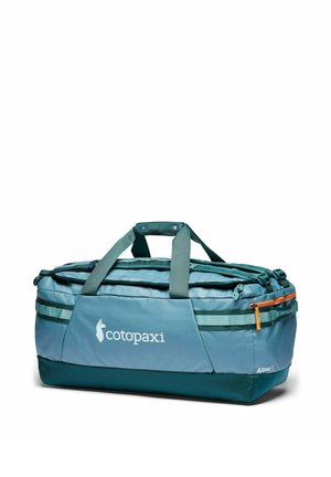 Bolsa de viaje Cotopaxi Allpa 70 azul y verde con asas superiores, correas laterales y una cremallera naranja sobre un fondo blanco.