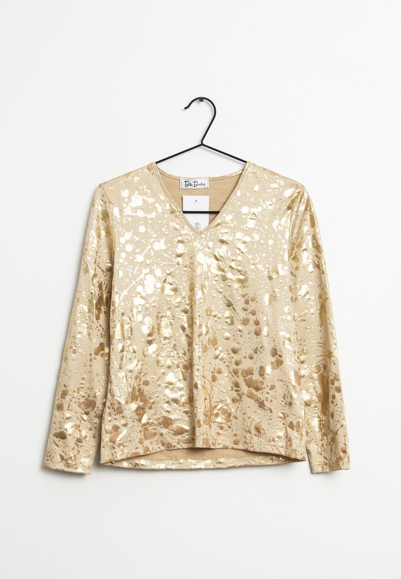 Gul metallisk långärmad skjorta med V-ringning, prydd med ett sprutmönster och slät, glansig yta. Visas på en galge.