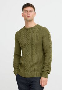 Pulover verde tricotat, cu modele cable, guler rotund ribbed și detalii texturate pe mâneci și torace.