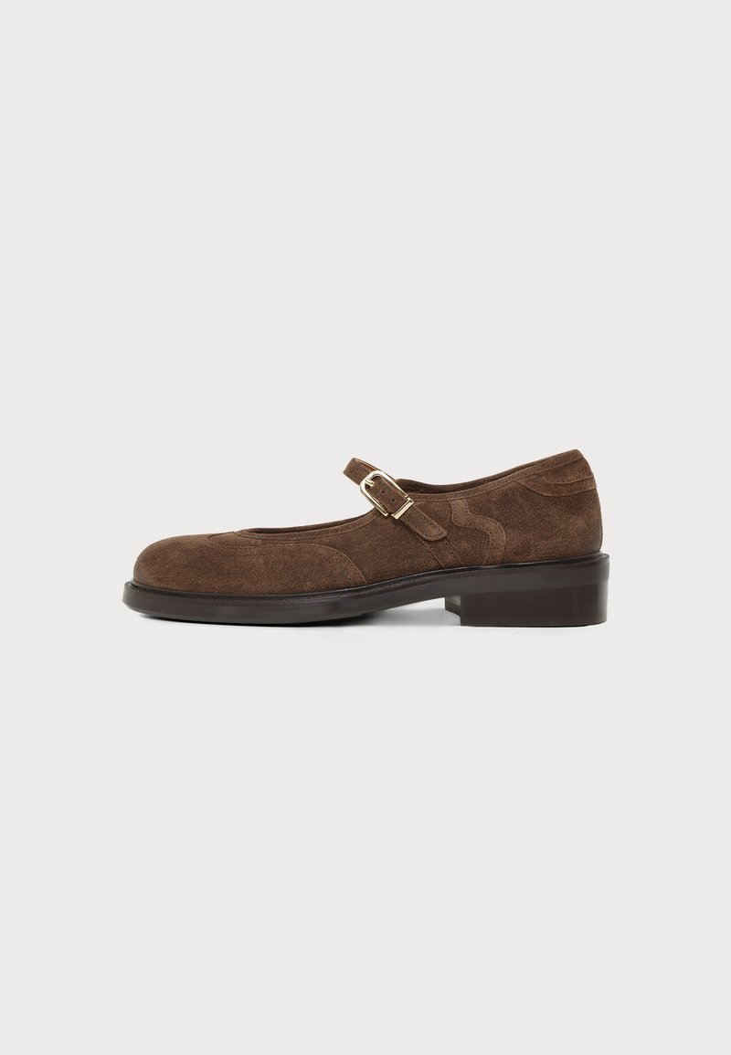 Chaussure Mary Jane en daim brun avec bride à boucle dorée, petit talon et bout arrondi, vue de profil sur fond uni.