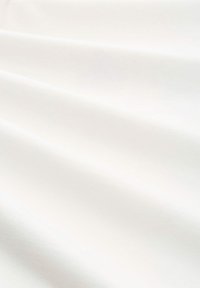 Witte stof met een gladde textuur, met zachte plooien en een subtiele glans. Het materiaal lijkt lichtgewicht en veelzijdig.