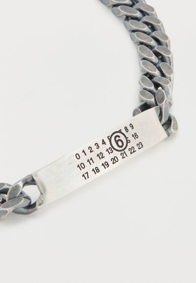 Ασημένιο βραχιόλι με σχεδιασμό αλυσίδας, που διαθέτει ένα επίπεδο ορθογώνιο ταμπελάκι με αριθμούς και τον εμφανή αριθμό "6".