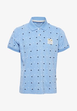 Polo bleu clair en coton avec col, comportant un motif de pois bleu foncé et de losanges blancs, ainsi qu'une petite étiquette en forme de palmier.
