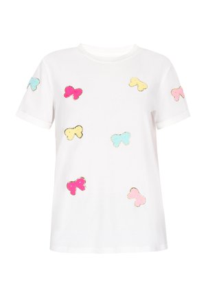 Valkoinen lyhythihainen t-paita, jossa on värikkäitä perhosikoristeita vaaleanpunaisena, keltaisena ja sinisenä, kultaisilla yksityiskohdilla korun ympärillä.