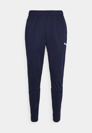 Pantalons de sport bleu marine en tissu doux, dotés d'une taille élastique et de rayures blanches sur les côtés. Comprend un petit logo sur la cuisse.